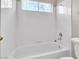 Clean bathroom featuring a tub/shower combination, white tile, and a window for natural light at 2617 Huber Heights Dr, Las Vegas, NV 89128