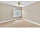 Bright, minimalist bedroom with wood floors, a ceiling fan, and a large window at 2617 Huber Heights Dr, Las Vegas, NV 89128