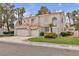 Beautiful two-story house featuring a three-car garage, tile roof, and lush landscaping at 2617 Huber Heights Dr, Las Vegas, NV 89128