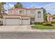 Two-story home with a three-car garage, red tile roof, and manicured lawn at 2617 Huber Heights Dr, Las Vegas, NV 89128