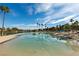 Community lagoon featuring beach access, palm trees, and lifeguard chairs under a blue sky at 2617 Huber Heights Dr, Las Vegas, NV 89128