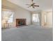 Living room with brick fireplace, gray carpeting, and large windows at 321 Carrington St, Henderson, NV 89074