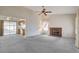 Open living room with fireplace, kitchen view, and ceiling fan at 321 Carrington St, Henderson, NV 89074