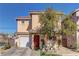 Two-story house with tan exterior, red door, and attached garage at 3728 Spiritual Way, Las Vegas, NV 89115