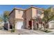 Two-story house with tan exterior, red door, and attached garage at 3728 Spiritual Way, Las Vegas, NV 89115