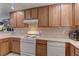 Kitchen with wood cabinets, white appliances, and tile flooring at 3728 Spiritual Way, Las Vegas, NV 89115