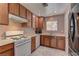 Kitchen with wood cabinets, white appliances, and tile flooring at 3728 Spiritual Way, Las Vegas, NV 89115