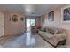 Living room with beige sofa, tiled floor, and access to patio at 3728 Spiritual Way, Las Vegas, NV 89115