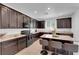 Modern kitchen featuring dark wood cabinets, granite countertops, and an island with seating at 3792 Nerine Pass Way Ave, North Las Vegas, NV 89031