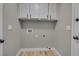 Simple laundry room with white cabinets and light grey walls at 3849 Boca Chica Ave, Las Vegas, NV 89120