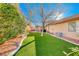 Landscaped backyard with artificial turf and a tree at 3918 Champagne Wood Dr, North Las Vegas, NV 89031