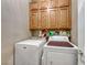 Bright laundry room with washer, dryer, and ample storage cabinets at 3918 Champagne Wood Dr, North Las Vegas, NV 89031