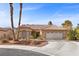 Single-story house with tan walls, tile roof, and a two-car garage at 4609 Snowpoint Ct, Las Vegas, NV 89130