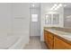 Bathroom with double vanity, granite countertop, and tiled tub at 5400 Flowing Spring St, Las Vegas, NV 89122