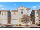 Two story house with tan exterior, white garage door, and landscaping at 5400 Flowing Spring St, Las Vegas, NV 89122