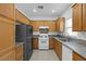 Kitchen with wood cabinets, granite counters, and white appliances at 5400 Flowing Spring St, Las Vegas, NV 89122