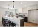 Modern kitchen with white cabinets, center island, and breakfast bar at 5904 Willowcreek Rd, North Las Vegas, NV 89031