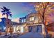 Two-story house with attached garage, landscaping, and desert trees at dusk at 624 Via Colmo Ave, Henderson, NV 89011