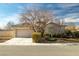 One-story home with a neutral color scheme and mature tree at 6436 Emerson St, Pahrump, NV 89048