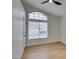 Well-lit bedroom with arched window and wood-look floors at 7812 Desert Candle Way, Las Vegas, NV 89128