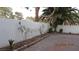 Backyard paver patio area has a white fence and planting beds at 8416 Shore Breeze Dr, Las Vegas, NV 89128