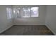 Bright bedroom featuring plush gray carpet and multiple windows letting in natural light at 8416 Shore Breeze Dr, Las Vegas, NV 89128