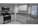 Kitchen featuring stainless steel oven, gray cabinetry and granite countertops at 8416 Shore Breeze Dr, Las Vegas, NV 89128