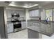 Well-lit kitchen with gray cabinets, stainless steel appliances, and granite countertops at 8416 Shore Breeze Dr, Las Vegas, NV 89128