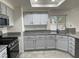 Well-lit kitchen with granite counters, gray cabinets and stainless steel appliances at 8416 Shore Breeze Dr, Las Vegas, NV 89128