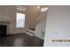 Bright living room with fireplace, wood floors, and a staircase with white railing at 8416 Shore Breeze Dr, Las Vegas, NV 89128