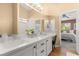 Elegant bathroom featuring a double vanity and a view into the bedroom at 8437 Sluman Ct, Las Vegas, NV 89128