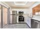 Modern kitchen with stainless steel appliances, white cabinetry, and wood-look flooring at 8617 Prairie Hill Dr, Las Vegas, NV 89134