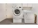 Modern laundry room with front loading washer and dryer, and white shaker style cabinets above appliances at 8617 Prairie Hill Dr, Las Vegas, NV 89134