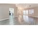 Open living room with wood-look flooring, neutral paint colors, and a partial view of kitchen at 8617 Prairie Hill Dr, Las Vegas, NV 89134