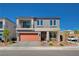 Two story home with modern design, balcony, orange garage door and desert landscaping at 8749 Black Cordon Rd, Las Vegas, NV 89139