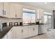 Kitchen with white cabinets, granite countertops, and a view of the backyard at 8749 Black Cordon Rd, Las Vegas, NV 89139