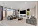 Modern living room with large windows, plush seating, fireplace, and mounted TV at 8749 Black Cordon Rd, Las Vegas, NV 89139