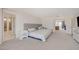 Bright bedroom features a king bed, neutral carpeting, and seamless access to the hallway, bath, and living room at 8749 Black Cordon Rd, Las Vegas, NV 89139