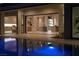 Luxury pool with a view into the home's interior at night at 8913 Canyon Springs Dr, Las Vegas, NV 89117