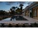 Modern rectangular pool with fire pit and patio at dusk at 8913 Canyon Springs Dr, Las Vegas, NV 89117