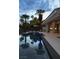 Modern rectangular pool with fire pit and patio at dusk at 8913 Canyon Springs Dr, Las Vegas, NV 89117