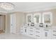 Modern bathroom with double vanity, marble countertops, and LED lit mirrors at 9113 Harvest Homes St, Las Vegas, NV 89123