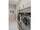 Laundry room with modern washer and dryer, white cabinets, and marble floors at 9113 Harvest Homes St, Las Vegas, NV 89123