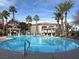 Community pool with surrounding lounge chairs and palm trees at 950 Seven Hills Dr # 2413, Henderson, NV 89052