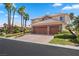 Two-story house with three-car garage, tile roof, and lush landscaping at 9523 Castillana Ct, Las Vegas, NV 89147