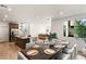 Open-concept dining area boasts modern furnishings, a view of the kitchen island and bright natural light at 3243 Fountaintree Ave, Henderson, NV 89044