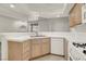 Kitchen with light wood cabinets, white appliances, and a double sink at 3604 Monarcas St # 101, Las Vegas, NV 89108