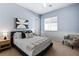 Bright bedroom with a queen bed, comfortable armchair, and wood-toned nightstand at 5455 San Florentine Ave, Las Vegas, NV 89141