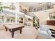 Open-concept living area with pool table, staircase, bar, and comfortable seating at 5455 San Florentine Ave, Las Vegas, NV 89141