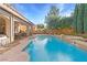 Backyard pool and spa with covered patio, seating, and lush landscaping at 5455 San Florentine Ave, Las Vegas, NV 89141